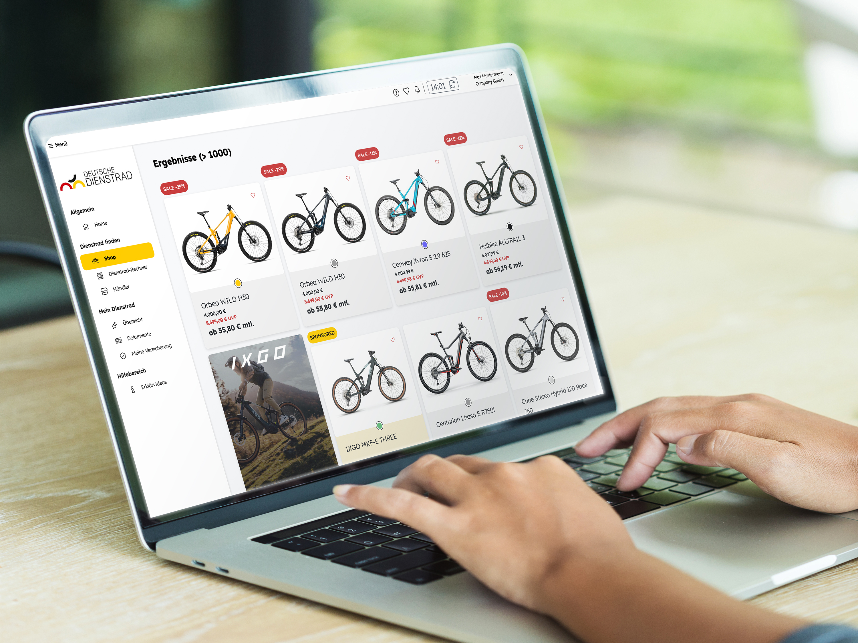 Hände tippen auf einem Laptop, auf dessen Bildschirm ein Online-Shop mit vielen Fahrrad-Angeboten in einer Produktübersicht geöffnet ist.