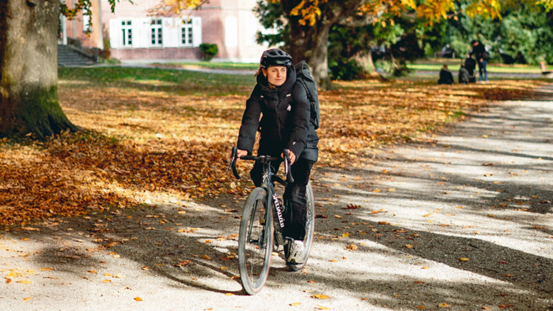 Eine Fahrradfahrerin im Herbst